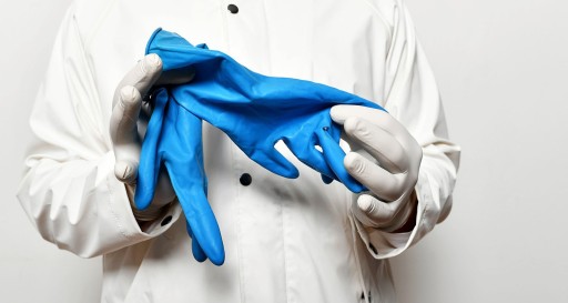 Tastuntersuchung zur Früherkennung von Prostatakrebs ungeeignet Arzt mit Kittel hält blaue Handschuhe