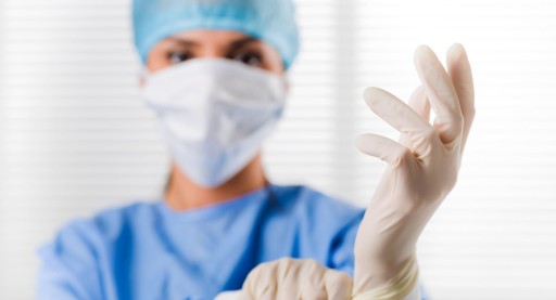 Tastuntersuchung zur Früherkennung von Prostatakrebs vor dem Aus Prostata Hilfe Deutschland: Ärztin zieht sich Handschuhe an